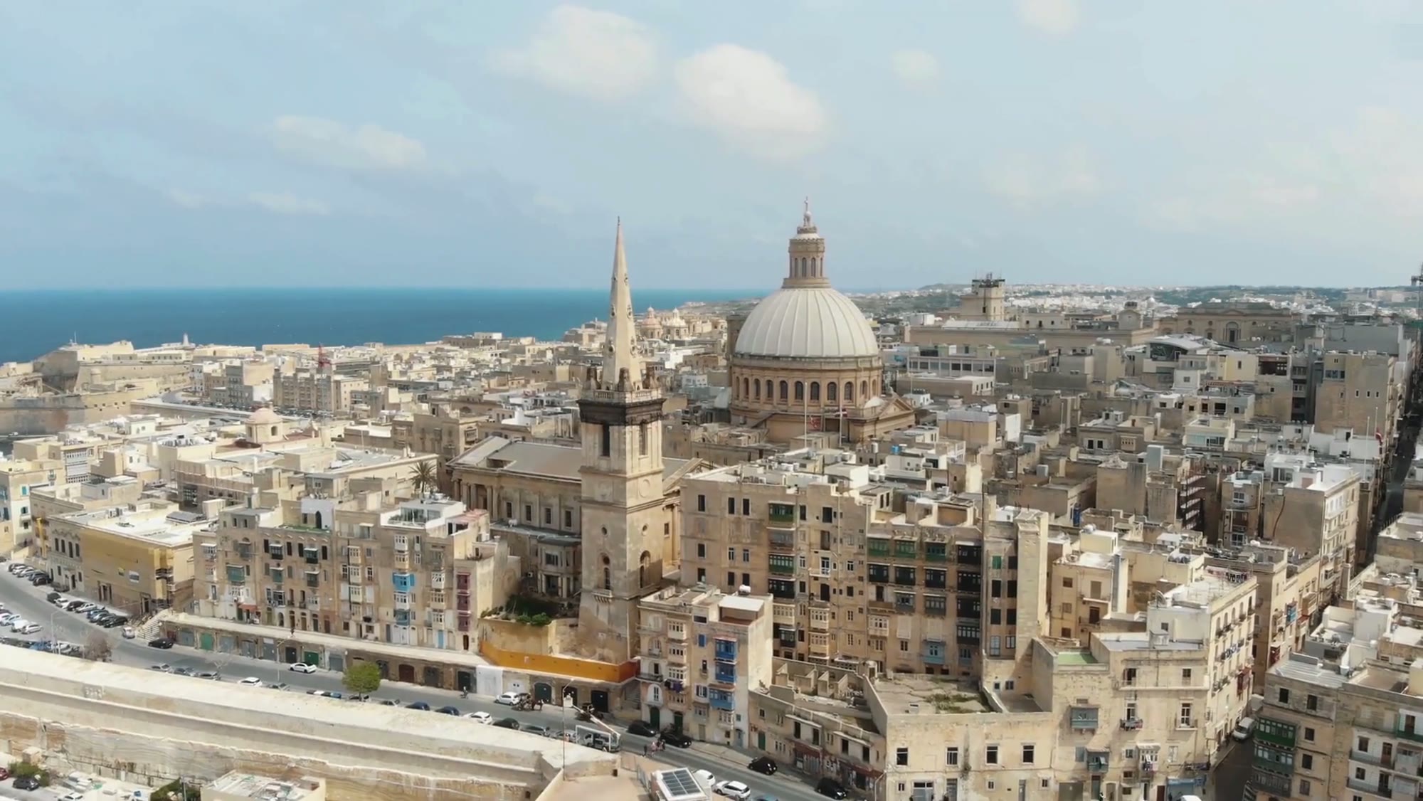 Aerial view of Valletta from the harbour — the Carmelite Church dome and St Paul's steeple over the city's limestone walls